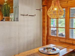 a dining room with a table and a chandelier at Holiday Home Annas beach by Interhome in Haminankylä