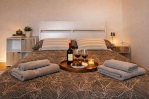 a bed with a table with wine glasses and wine bottles at Little Urban Home in Trieste +11 photos