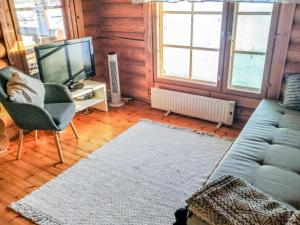 a living room with a couch and a tv at Holiday Home Sillankorva by Interhome in Korpijärvi