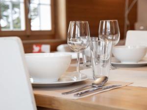 a table with two wine glasses and bowls on it at Holiday Home Chalet Reinhysi by Interhome in Grindelwald