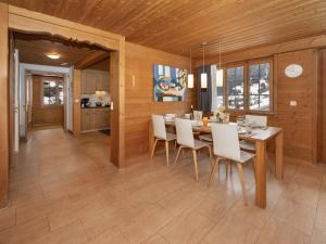 a dining room with a table and white chairs at Holiday Home Chalet Reinhysi by Interhome in Grindelwald