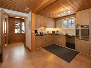 a kitchen with wooden cabinets and a stove top oven at Holiday Home Chalet Reinhysi by Interhome in Grindelwald +35 photos