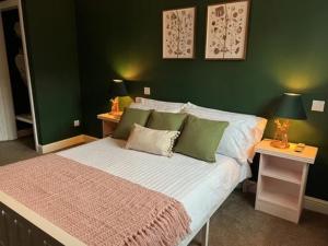 a bedroom with a large bed with green walls at Ye Olde Crown in Edenbridge