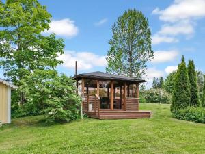 a wooden gazebo in a field with trees at Holiday Home Salmiranta by Interhome in Jämijärvi