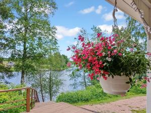 a flower pot hanging from a porch with a view of a river at Holiday Home Salmiranta by Interhome in Jämijärvi