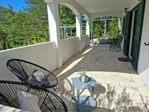 a patio with a chair and a table on a porch at Apartman MAKA in Kučiće
