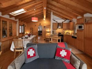 a living room with a couch and a kitchen at Chalet Ropiar by Interhome in Ovronnaz