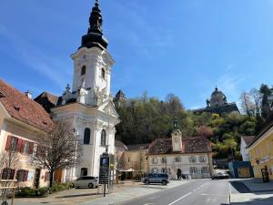a church with a clock tower on the side of a street at Zur goldenen Krone in Ehrenhausen
