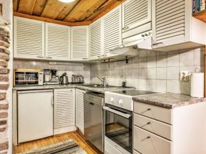 a kitchen with white appliances and a wooden ceiling at Holiday Home Luppokero 2 by Interhome in Pyhätunturi