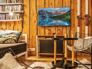 a living room with a tv on a wooden wall at Holiday Home Luppokero 2 by Interhome in Pyhätunturi +19 photos