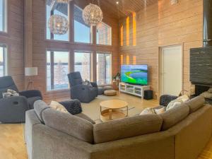 a living room with a large couch and a television at Holiday Home Leinola by Interhome in Sotkamo