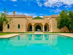 a large house with a swimming pool in front of it at Privat Villa in Marrakesch with Pool & Garten in Marrakesh