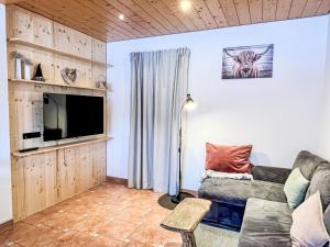 a living room with a couch and a tv at Apartment Fewo Knöpfle by Interhome in Eisenbach