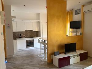 a living room with a tv and a kitchen at La Concordia in Novi Ligure