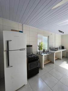 a large kitchen with a refrigerator and a sink at Morá 2 Coliving in Cachoeirinha