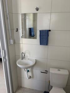 a bathroom with a sink and a toilet and a mirror at Morá 2 Coliving in Cachoeirinha