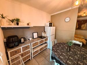 a small kitchen with a refrigerator and a table at Buffelsrivier Farm Stay in Laingsburg +8 photos