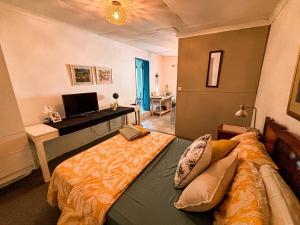 a bedroom with a bed and a desk with a computer at Buffelsrivier Farm Stay in Laingsburg