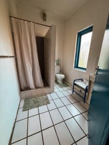 a bathroom with a shower and a toilet in it at Buffelsrivier Farm Stay in Laingsburg