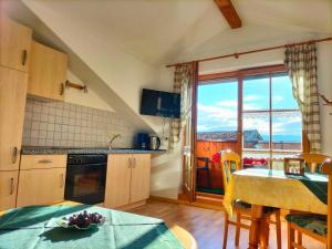 a kitchen with a table and a view of the ocean at Ferienhof Wolf in Viechtach