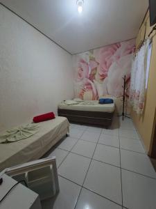 a room with two beds and a painting on the wall at Hotel Padre Vitor in Aparecida