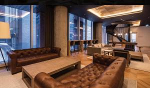 a lobby with leather couches and tables and a bar at Luxury Apartments with View & Indoor Heated Pool in Montreal
