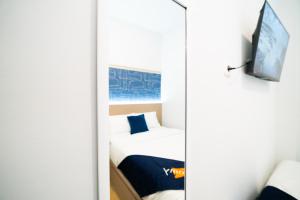 a mirror in a room with a bed and a tv at Behomy Boarding Ciledug in Pasarjumahat-Kulon