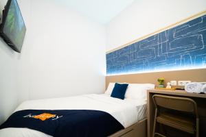 a bedroom with a bed and a chalkboard on the wall at Behomy Boarding Ciledug in Pasarjumahat-Kulon