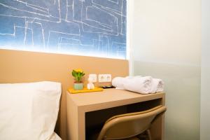 a desk with a chair next to a bed at Behomy Boarding Ciledug in Pasarjumahat-Kulon