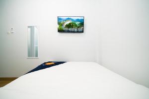 a bed in a room with a picture on the wall at Behomy Boarding Ciledug in Pasarjumahat-Kulon