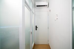 a hallway with a white door and a white wall at Behomy Boarding Ciledug in Pasarjumahat-Kulon