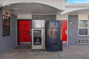 an old soda machine sitting outside of a building at Golden Inn Dallas by Hotel O in Dallas