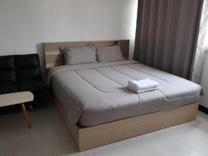 a bed in a small room with a chair at Hi Impact Muangthong T9 in Nonthaburi
