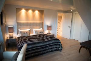 a bedroom with a large bed with lights on the wall at Rantum Lodge in Rantum