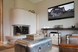 a living room with a fireplace and an old suitcase at Rantum Lodge in Rantum
