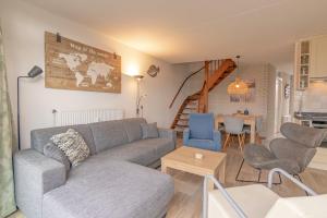 a living room with a couch and chairs and a table at Seinpost Appartment in Callantsoog