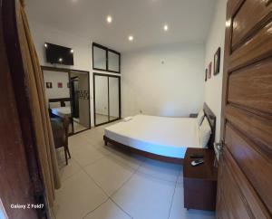 a bedroom with a bed and a chair in it at Hotel Nhungue & Shopping Lda in Tete