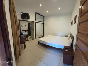 a bedroom with a bed and a table and a chair at Hotel Nhungue & Shopping Lda in Tete