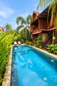a swimming pool in front of a house at Putra Bali Villa by Antara in Klungkung
