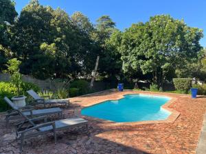 a swimming pool with two lawn chairs and a table at Kasteelberg View in Riebeek-Wes