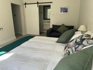 a large white bed in a room with a couch at Kasteelberg View in Riebeek-Wes