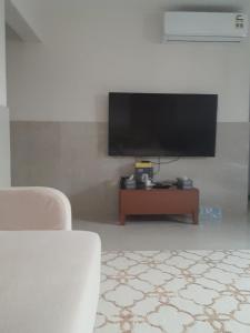 a living room with a flat screen tv on a wall at Room Quriyat in Ramlah