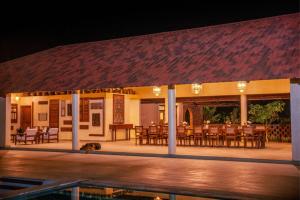 a restaurant with tables and chairs at night at Krsna Farm Villa in Bangalore