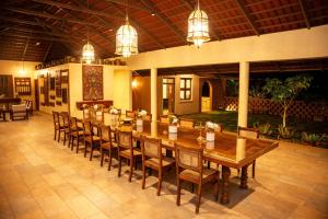 a large dining room with a long table and chairs at Krsna Farm Villa in Bangalore