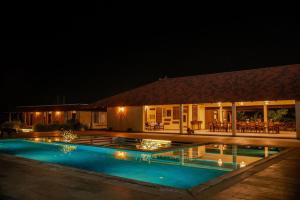 a house with a swimming pool at night at Krsna Farm Villa in Bangalore