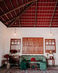 a living room with a couch and two windows at Krsna Farm Villa in Bangalore