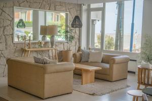 ein Wohnzimmer mit zwei Sofas und einem Tisch in der Unterkunft Hotel Las Rocas in Mar del Plata