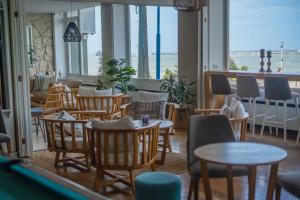 ein Restaurant mit Tischen und Stühlen und Meerblick in der Unterkunft Hotel Las Rocas in Mar del Plata