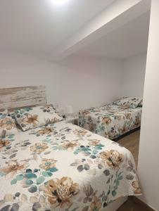 a bedroom with a bed with a floral bedspread at Casa rural El Terreno in Teruel +16 photos