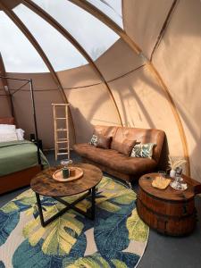 a room with a couch and tables in a yurt at La Découverte Trouvée in Auxon +242 photos
